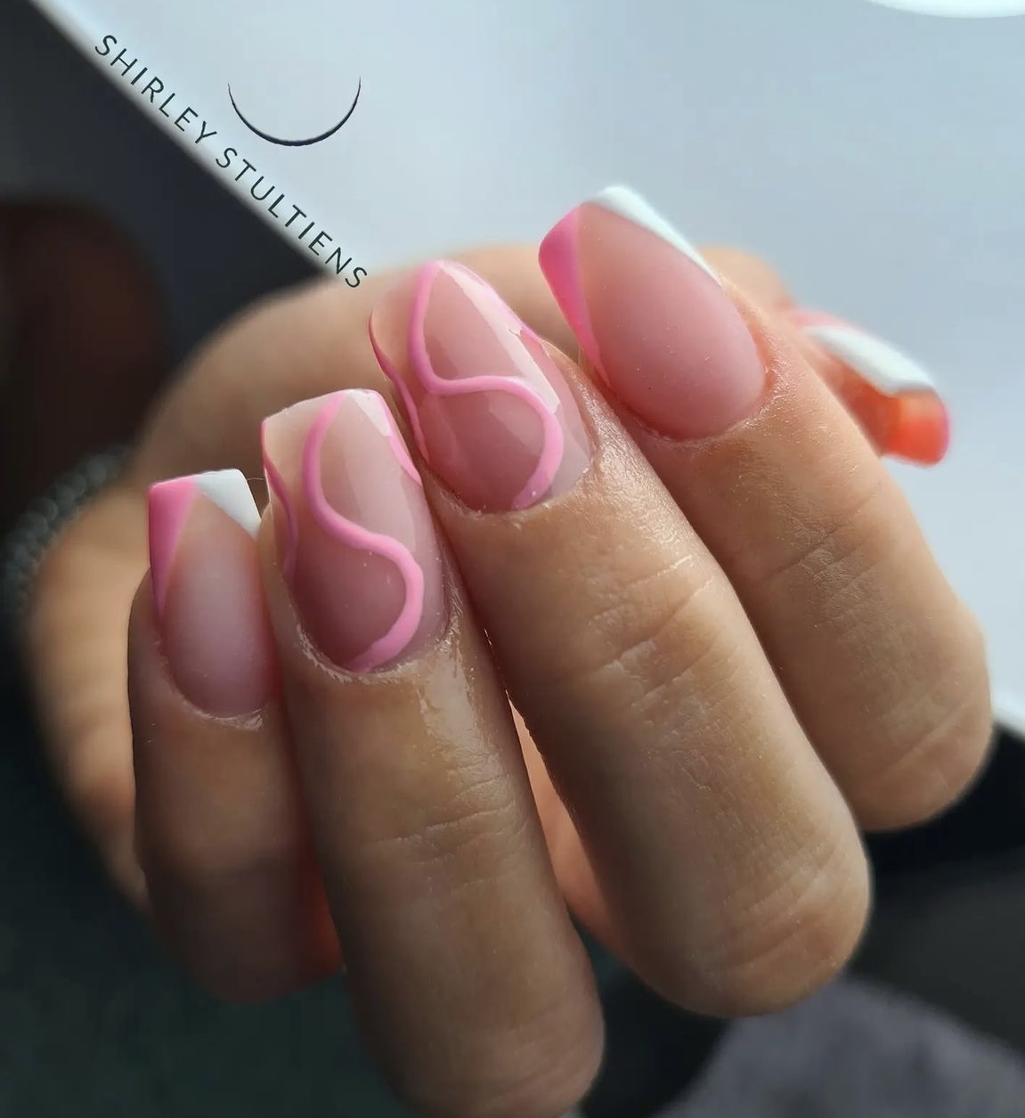 Nude nagels met roze lijntjes en een oranje met witte french, foto van Maudy